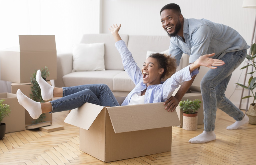 Excited man riding woman in new home